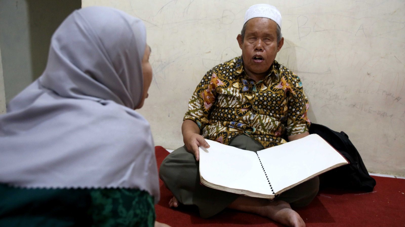 Pengajar membimbing santri tunanetra membaca mushaf Al-Qur'an Braille